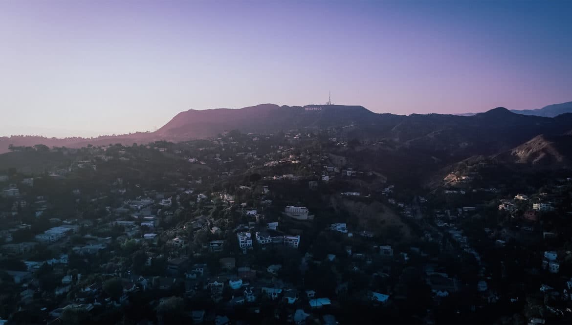 an aerial view of a city with mountains in the background.