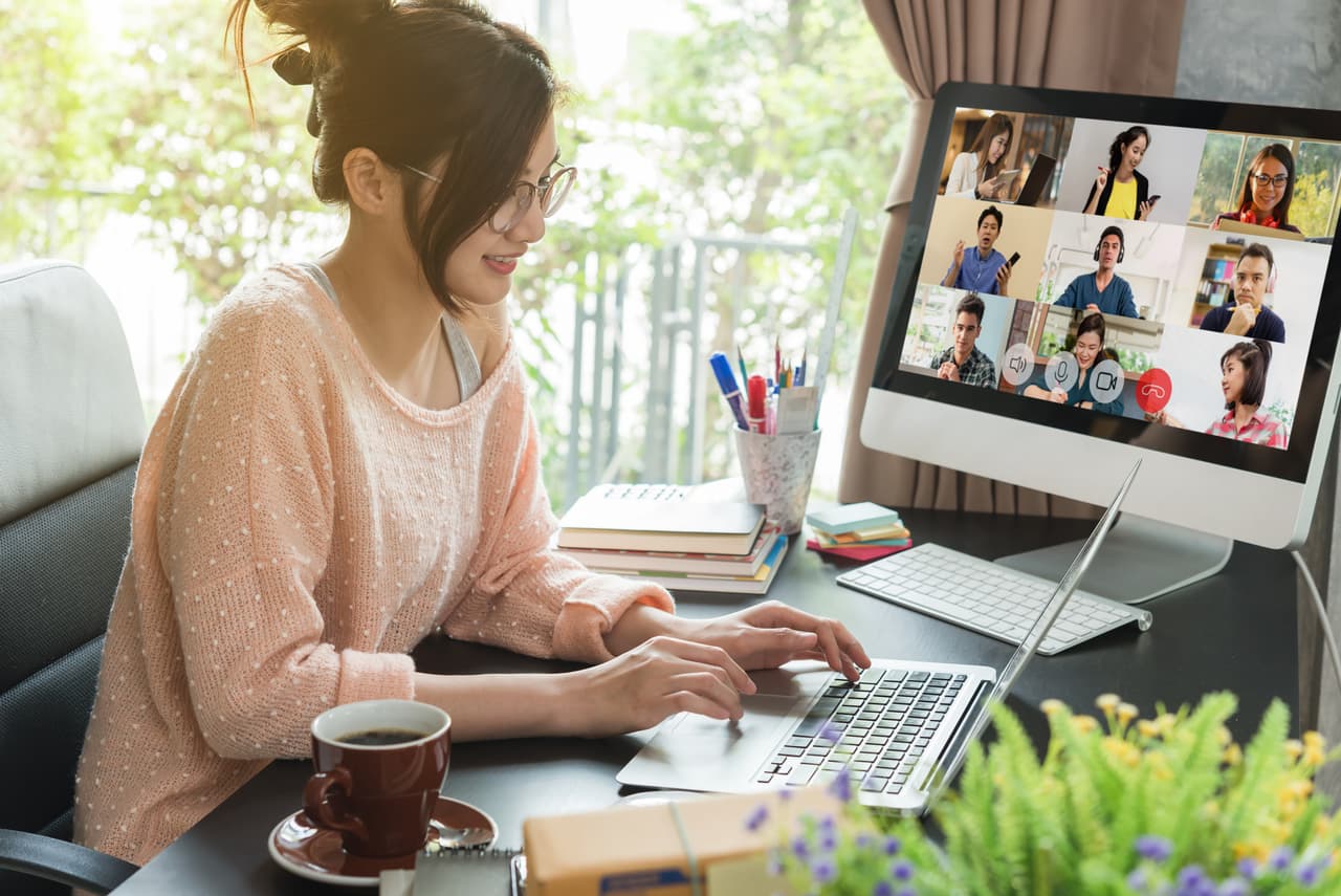 a woman is using a computer for a video call across different time zones.